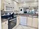 Efficient kitchen with stainless steel appliances, white cabinetry, and a breakfast bar at 4440 47Th W Ave # 204, Bradenton, FL 34210