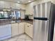 Kitchen featuring stainless steel refrigerator and appliances, and breakfast bar pass-through to living area at 4440 47Th W Ave # 204, Bradenton, FL 34210
