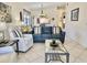 Inviting living room featuring a plush blue sofa, tile flooring, and bright natural light at 4440 47Th W Ave # 204, Bradenton, FL 34210