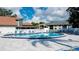 Community pool surrounded by gray tiles, lounge chairs, and nice buildings under a blue sky at 4440 47Th W Ave # 204, Bradenton, FL 34210