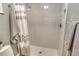 Bathroom walk-in shower with neutral tile surround, shower curtain, and gray towels at 4712 Glenbrooke Dr, Sarasota, FL 34243
