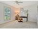 Bright bedroom with neutral carpet, ceiling fan, and window shutters for natural light at 4712 Glenbrooke Dr, Sarasota, FL 34243