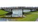 Scenic view of the bridge reflected in the water, surrounded by green grassy banks and clear blue skies at 4712 Glenbrooke Dr, Sarasota, FL 34243