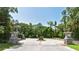 Community entry gate with stone pillars surrounded by mature trees, ensures privacy and prestige at 4712 Glenbrooke Dr, Sarasota, FL 34243