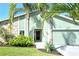 Close up of the front entry showcasing a well maintained lawn, mature palm trees, and stone accents at 4712 Glenbrooke Dr, Sarasota, FL 34243