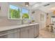 Bright kitchen features light wood cabinets, stainless steel dishwasher, quartz counters, and tiled floor at 4712 Glenbrooke Dr, Sarasota, FL 34243