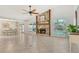 Spacious living room featuring a stone fireplace, tile floors, large windows, and a ceiling fan, perfect for gatherings at 4712 Glenbrooke Dr, Sarasota, FL 34243