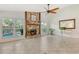 Bright living room showcasing a stone fireplace, tile floors, large windows overlooking the pool, and a ceiling fan at 4712 Glenbrooke Dr, Sarasota, FL 34243