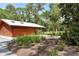 A modern restroom building with a metal roof provides convenient facilities amidst the lush greenery of the park at 4712 Glenbrooke Dr, Sarasota, FL 34243