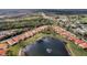 Aerial view of a community of homes with a large pond and fountain and a highway in the background at 4811 Summertree Rd, Venice, FL 34293