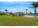 View of a beautiful backyard and community pool area with swaying palms at 4811 Summertree Rd, Venice, FL 34293