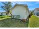 A view of the backyard showing the building exterior and manicured lawn of this charming home at 4811 Summertree Rd, Venice, FL 34293