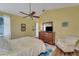 Comfortable bedroom featuring a ceiling fan, wood laminate flooring, and natural light at 4811 Summertree Rd, Venice, FL 34293