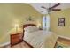 Comfortable bedroom featuring a ceiling fan, wood laminate flooring, and natural light at 4811 Summertree Rd, Venice, FL 34293