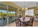 Dining room featuring a chandelier and large sliding doors to a screened patio at 4811 Summertree Rd, Venice, FL 34293