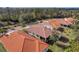 Aerial view of several homes with orange tile roofs on a sunny day with mature trees in the distance at 4811 Summertree Rd, Venice, FL 34293