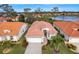 Inviting home featuring a terra cotta roof, landscaped front yard, and two-car garage at 4811 Summertree Rd, Venice, FL 34293