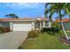 Charming home featuring a two-car garage, well-maintained lawn, and tasteful landscaping enhancing curb appeal at 4811 Summertree Rd, Venice, FL 34293