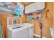 Functional laundry room with washer, dryer, shelving, and window for natural light at 4811 Summertree Rd, Venice, FL 34293