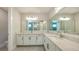 Large bathroom with dual sinks, marble countertops, modern finishes, and tile flooring at 512 Laurel Park Dr, Sarasota, FL 34236