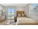 Bright bedroom featuring balcony access, wooden accent headboard, and a cowhide rug at 512 Laurel Park Dr, Sarasota, FL 34236