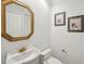 Elegant bathroom with a white pedestal sink, gold fixtures, and decorative framed artwork at 55 N Washington Dr, Sarasota, FL 34236