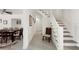 Bright hallway with staircase, leading to a dining room with wood table and chairs at 55 N Washington Dr, Sarasota, FL 34236