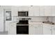 Updated kitchen features white cabinetry, marble countertops, stainless steel appliances, and ample storage at 55 N Washington Dr, Sarasota, FL 34236