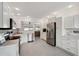 Bright kitchen with white cabinets, stainless steel appliances, and views to the living area at 55 N Washington Dr, Sarasota, FL 34236