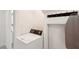 Functional laundry area featuring a washing machine, hanging rack, and ironing board at 55 N Washington Dr, Sarasota, FL 34236