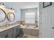 Bathroom featuring a dual sink vanity, a soaking tub, decorative accents, and a bright, airy atmosphere at 6161 Anise Dr, Sarasota, FL 34238