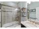Well-lit bathroom features a tiled shower and tub, with a granite countertop sink and decorative shelving at 6161 Anise Dr, Sarasota, FL 34238