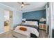 Bedroom featuring a blue accent wall, ceiling fan, and bright bathroom access at 6161 Anise Dr, Sarasota, FL 34238