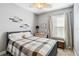 Cozy bedroom with a plaid comforter, ceiling fan, window with blinds, and neutral decor at 6161 Anise Dr, Sarasota, FL 34238