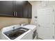 Convenient laundry room with a washer and dryer set, dark cabinets, and access door at 6161 Anise Dr, Sarasota, FL 34238
