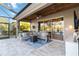 Cozy outdoor patio with a fire pit, sectional seating, grill, and views of the serene lake at 6161 Anise Dr, Sarasota, FL 34238