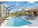 A tranquil screened pool area overlooks the green backyard with outdoor seating, which is perfect for entertaining at 6161 Anise Dr, Sarasota, FL 34238