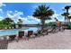 Community swimming pool surrounded by lounge chairs, umbrellas, and lush tropical landscaping at 6161 Anise Dr, Sarasota, FL 34238