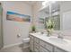 Bathroom with double sinks, framed mirrors, decorative flowers, and modern fixtures at 6306 115Th E Ave, Parrish, FL 34219