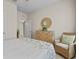 Cozy bedroom with a woven chair, light walls, and decorative mirror and dresser at 6306 115Th E Ave, Parrish, FL 34219