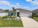 Attractive one-story home showcases a lush green lawn, verdant landscaping, and a convenient two-car garage at 6306 115Th E Ave, Parrish, FL 34219