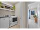 Laundry room with modern washer and dryer, overhead shelf, and view to bedroom at 6306 115Th E Ave, Parrish, FL 34219