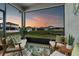 Scenic evening view from screened-in lanai with comfortable seating, overlooking backyard and pond at 6306 115Th E Ave, Parrish, FL 34219