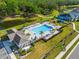 Aerial view of a community pool area with lounge chairs, palm trees, and nearby pond at 6306 115Th E Ave, Parrish, FL 34219