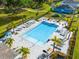 Aerial view of community pool area with plenty of lounge chairs, and a nearby playground and pond at 6306 115Th E Ave, Parrish, FL 34219