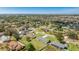 Aerial view of a single-story home surrounded by lush greenery in a vibrant neighborhood at 6349 5Th Street E Cir, Bradenton, FL 34203