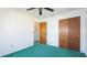 Bedroom features plush green carpet, a ceiling fan, and closet with paneled sliding doors at 6349 5Th Street E Cir, Bradenton, FL 34203