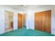 Bedroom with neutral walls, plush carpets, two wood doors and an adjacent bathroom, and natural light at 6349 5Th Street E Cir, Bradenton, FL 34203