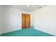 Bedroom with plush green carpet features a ceiling fan and closet with sliding doors at 6349 5Th Street E Cir, Bradenton, FL 34203