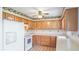 Charming kitchen featuring wood cabinets, light countertops, tile floors and backsplash, and fruit-themed wallpaper at 6349 5Th Street E Cir, Bradenton, FL 34203